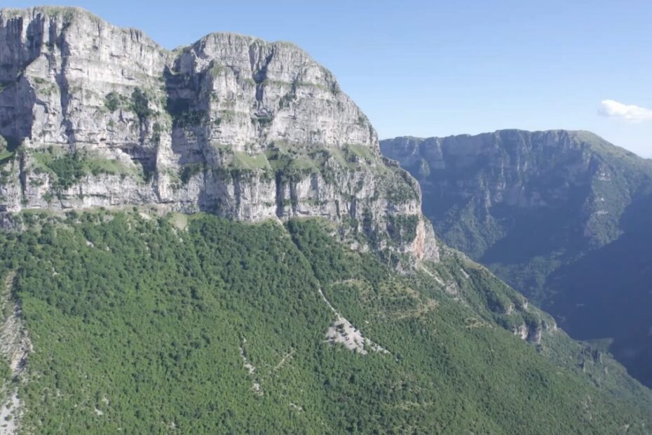 cliff face above wooded slope