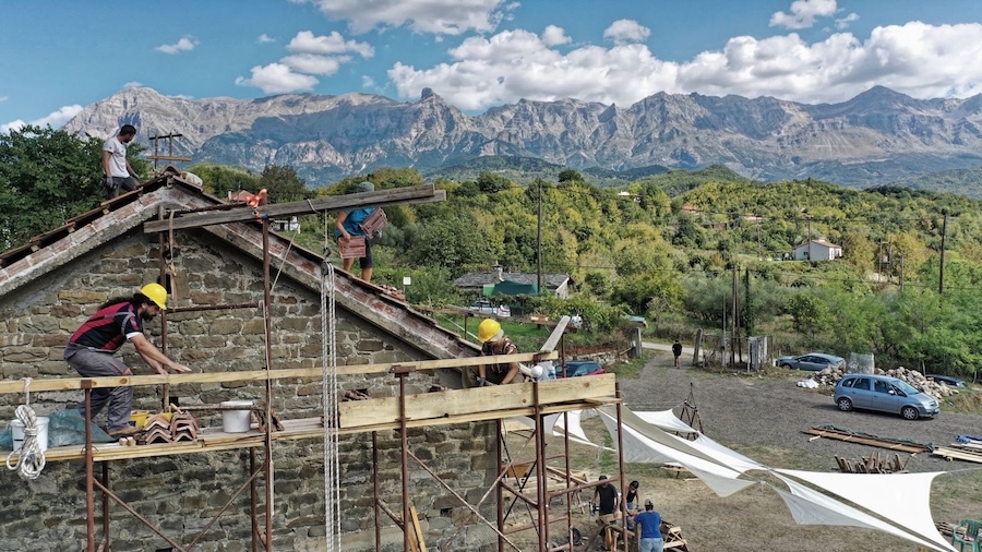 building work underway on scaffolding with mountains behind in the distance